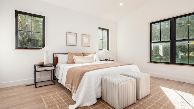 bedroom featuring light hardwood / wood-style flooring and lofted ceiling