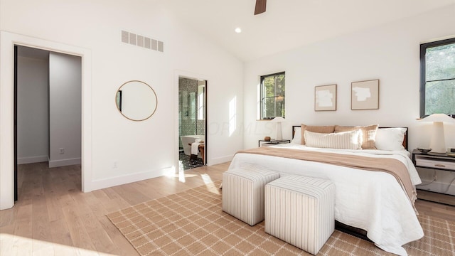 bedroom featuring lofted ceiling, ceiling fan, light wood-type flooring, and connected bathroom