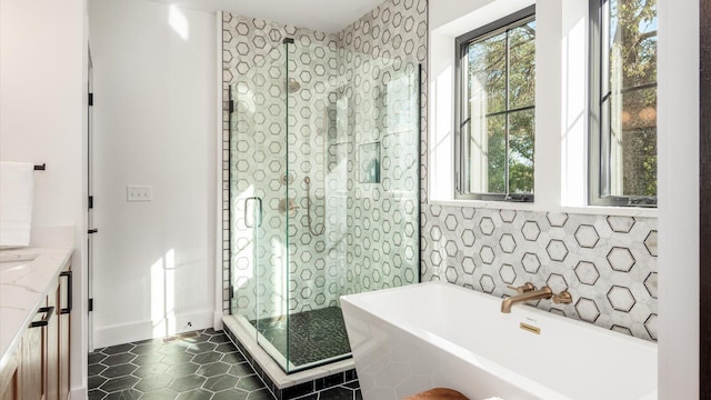 bathroom with tile patterned flooring, a bathtub, and vanity