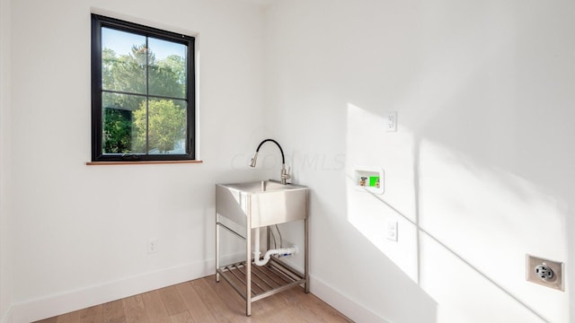 clothes washing area with sink, washer hookup, and light wood-type flooring