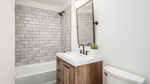 full bathroom featuring tiled shower / bath, vanity, and toilet