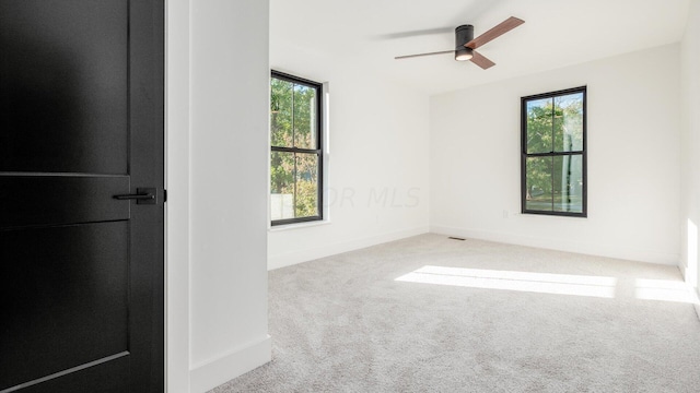 spare room with ceiling fan and light carpet