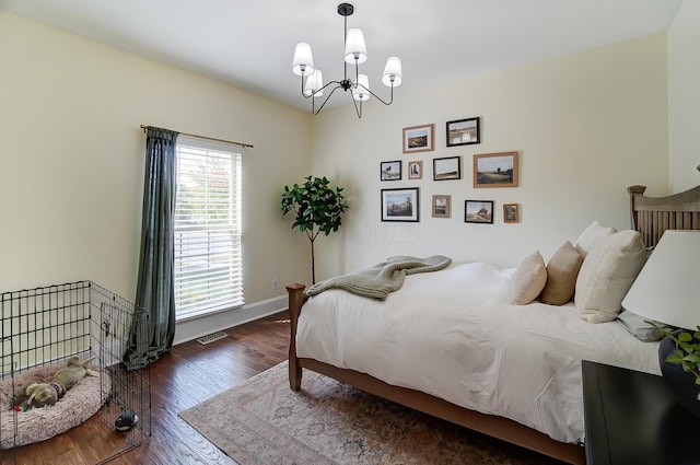 bedroom with an inviting chandelier and dark wood-type flooring