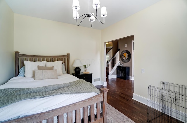 bedroom featuring dark wood-type flooring and a notable chandelier