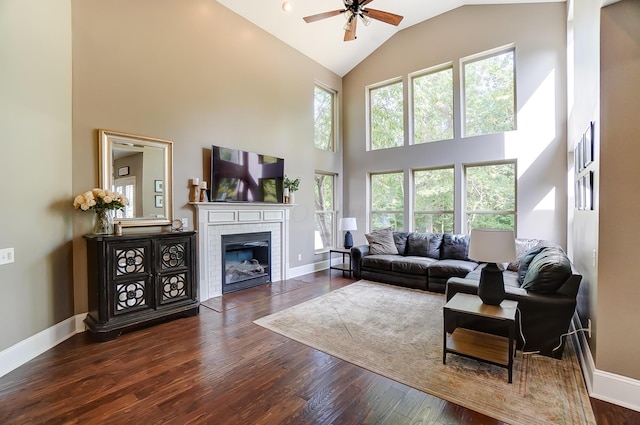 living room with plenty of natural light, ceiling fan, dark wood-type flooring, and high vaulted ceiling