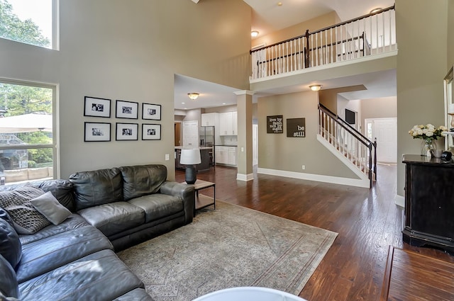 living room featuring dark wood-type flooring and a high ceiling