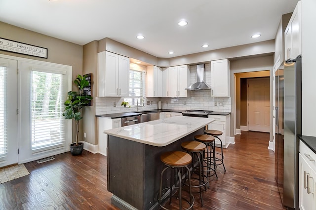 kitchen with white cabinets, dark hardwood / wood-style flooring, and wall chimney exhaust hood