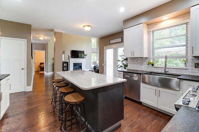 kitchen with dishwasher, sink, white cabinets, and dark wood-type flooring