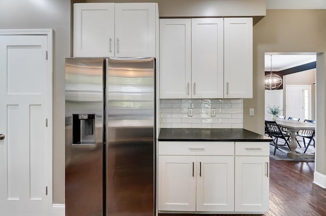 kitchen with stainless steel fridge with ice dispenser, white cabinets, dark wood-type flooring, and ornamental molding