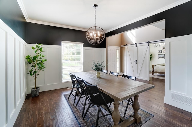 dining space with a barn door, crown molding, dark hardwood / wood-style floors, and a notable chandelier