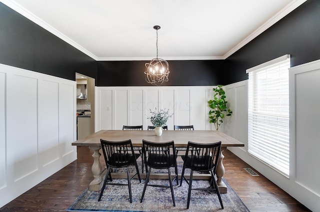 dining space with crown molding, dark wood-type flooring, and a notable chandelier