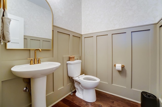 bathroom with hardwood / wood-style flooring, toilet, and sink