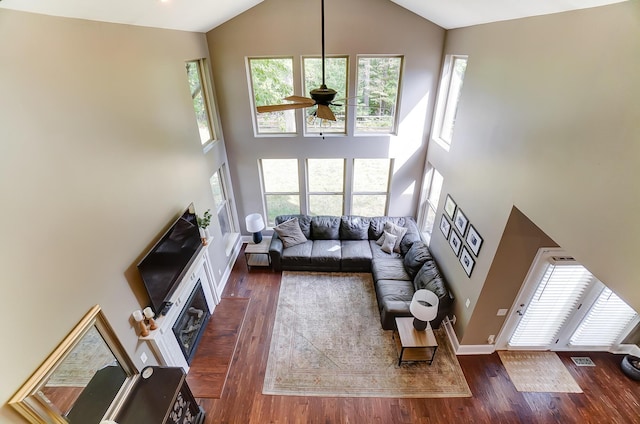 living room with ceiling fan, dark hardwood / wood-style flooring, and high vaulted ceiling