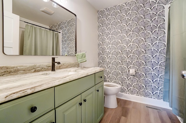 bathroom featuring vanity, hardwood / wood-style flooring, and toilet