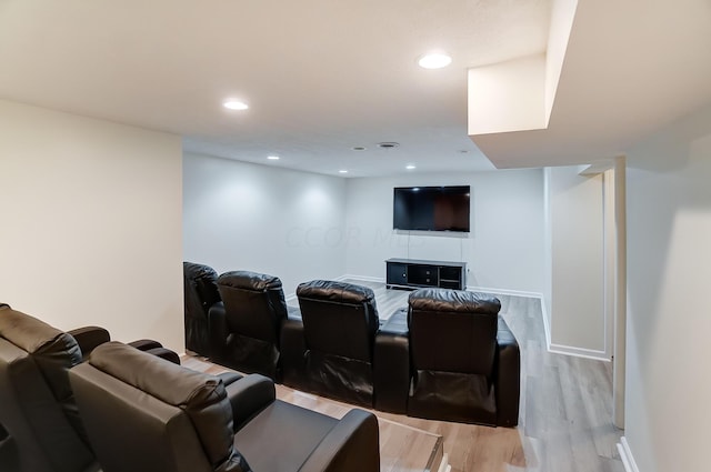 cinema room with light hardwood / wood-style floors