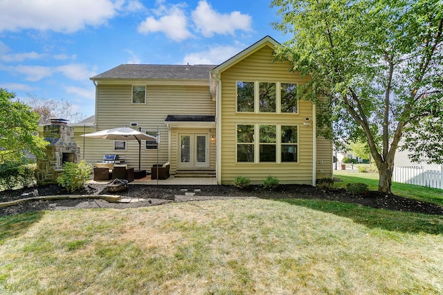 rear view of house with an outdoor living space with a fireplace, a patio area, and a yard