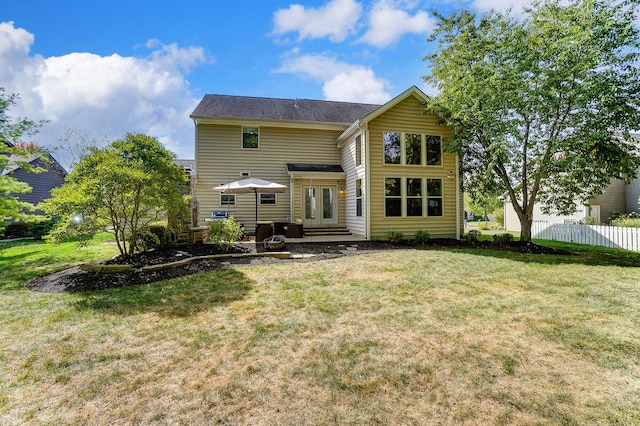 back of house featuring a lawn and french doors