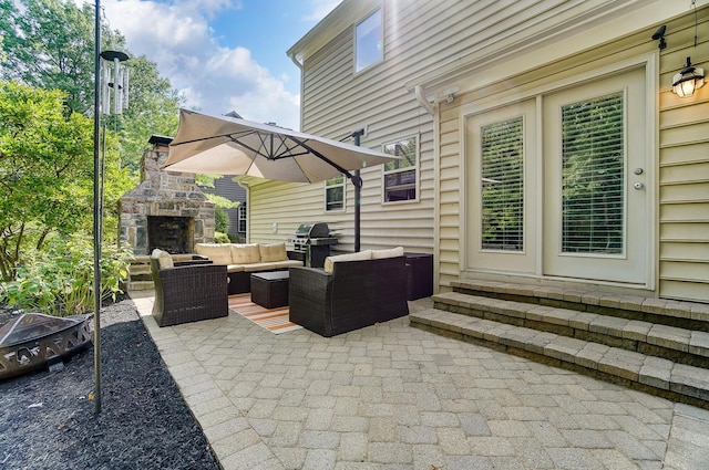 view of patio featuring an outdoor living space with a fireplace and area for grilling