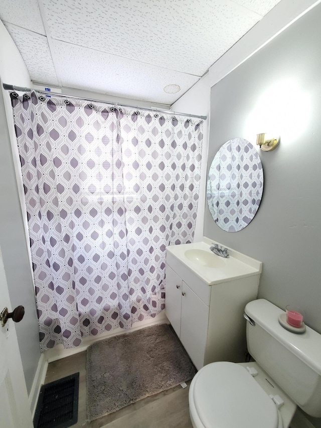 full bathroom featuring a paneled ceiling, vanity, shower / bath combo with shower curtain, hardwood / wood-style flooring, and toilet