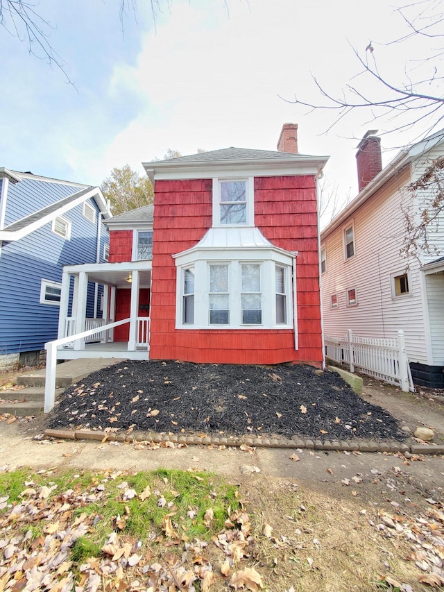 back of property featuring covered porch