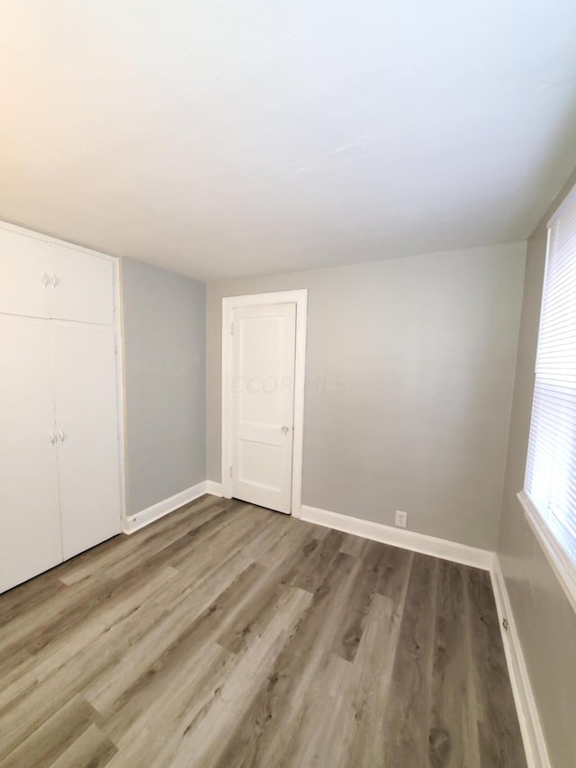 unfurnished bedroom with light wood-type flooring and a closet