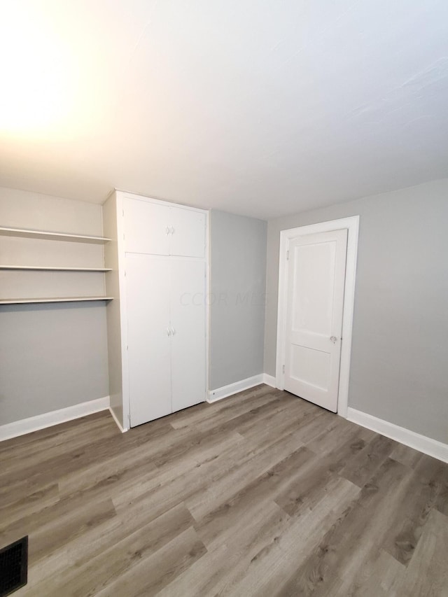 unfurnished bedroom with wood-type flooring and a closet