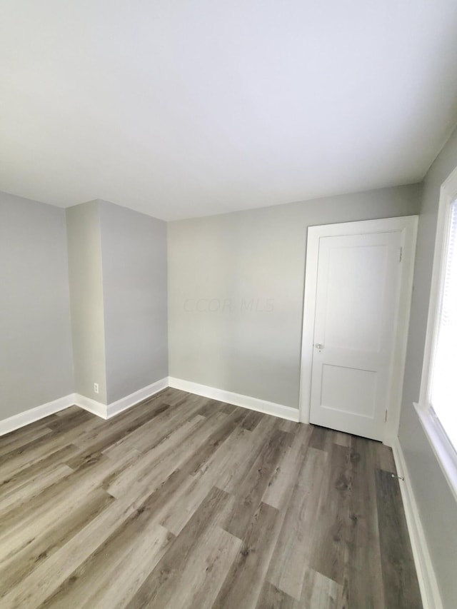 unfurnished room with wood-type flooring