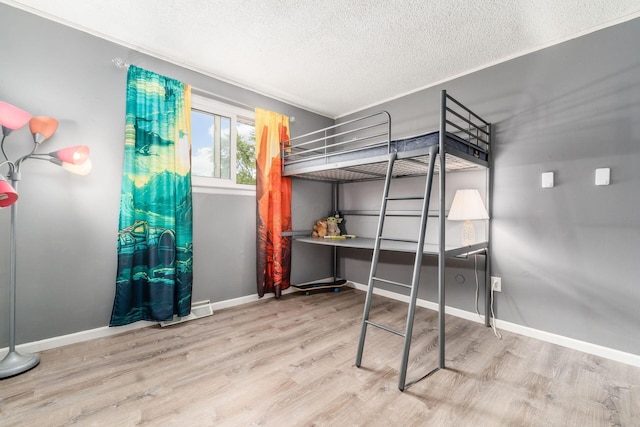 bedroom featuring a textured ceiling and light hardwood / wood-style flooring