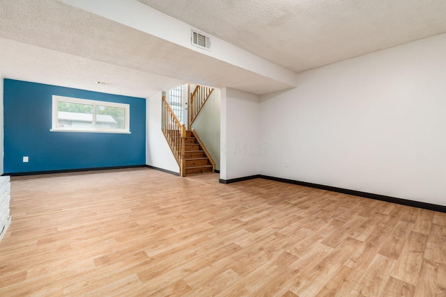 bonus room with a textured ceiling and light wood-type flooring