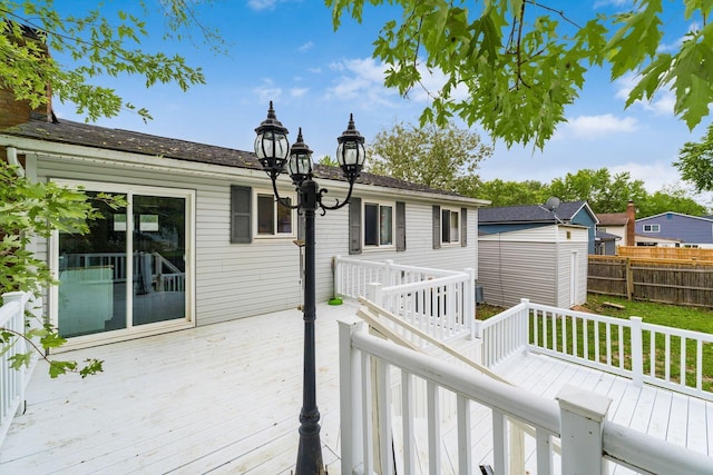 wooden deck featuring a storage unit and a yard