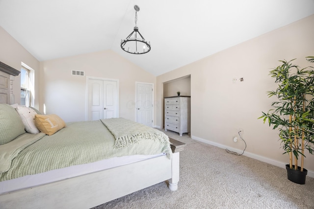 carpeted bedroom with vaulted ceiling and a notable chandelier