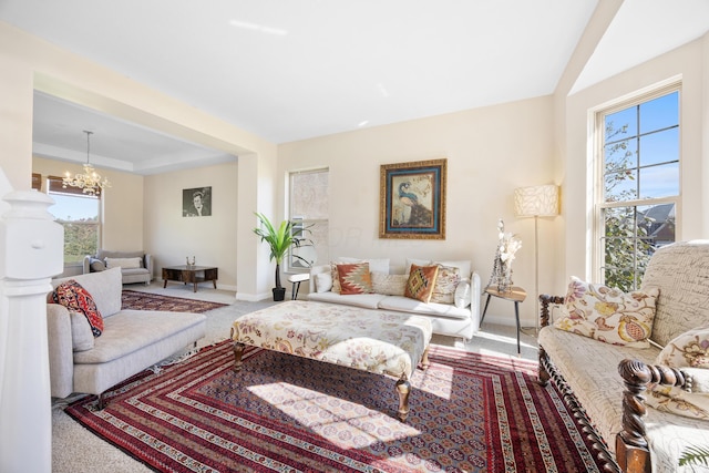 carpeted living room with a healthy amount of sunlight and a notable chandelier