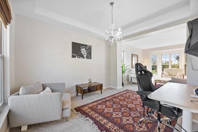 office area with light colored carpet, a tray ceiling, and a notable chandelier