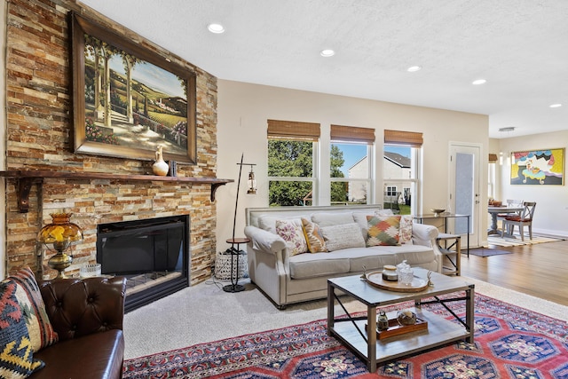 living room with a fireplace, wood-type flooring, and a textured ceiling