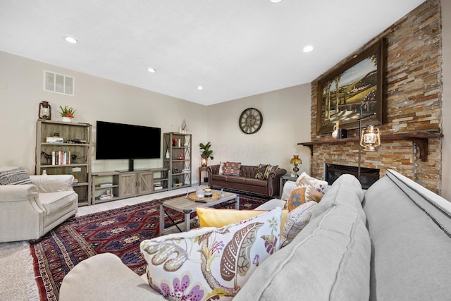 living room with carpet and a stone fireplace