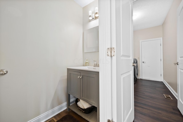 bathroom with vanity, wood-type flooring, and a textured ceiling