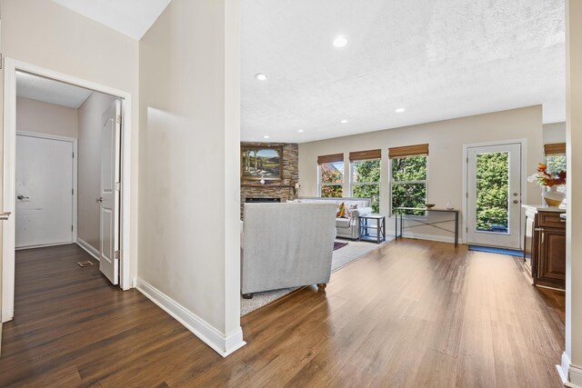 unfurnished living room with a textured ceiling, hardwood / wood-style flooring, and a wealth of natural light