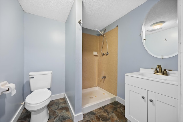 bathroom featuring vanity, a shower, toilet, and a textured ceiling