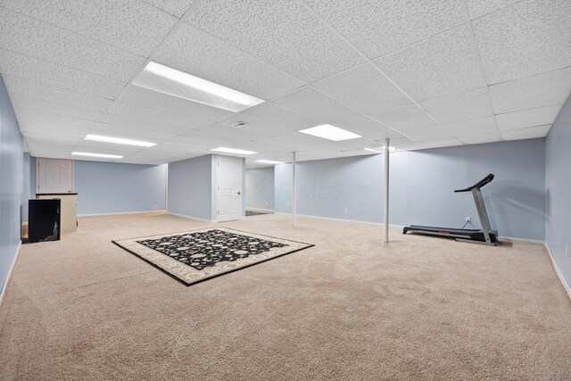 basement featuring light carpet and a drop ceiling