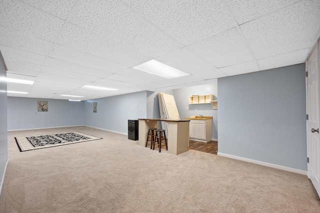 basement featuring carpet and a drop ceiling