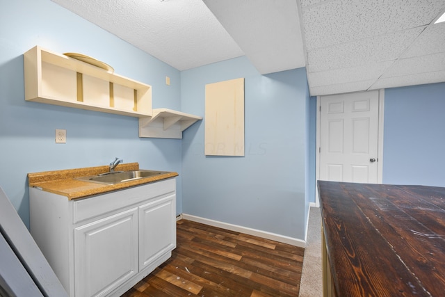 kitchen with white cabinets, sink, and dark wood-type flooring