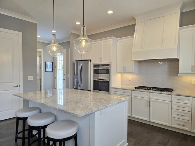 kitchen with stainless steel appliances, a center island, and white cabinetry