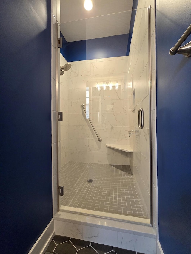 bathroom with a shower with door and tile patterned flooring