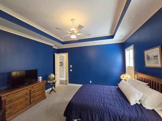 bedroom with a raised ceiling, ceiling fan, and carpet