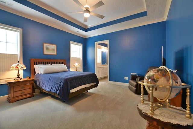 carpeted bedroom featuring connected bathroom, ceiling fan, and a tray ceiling