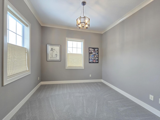 carpeted spare room featuring an inviting chandelier, crown molding, and a wealth of natural light