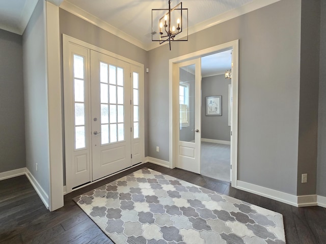 entrance foyer with ornamental molding, a notable chandelier, and dark wood-type flooring