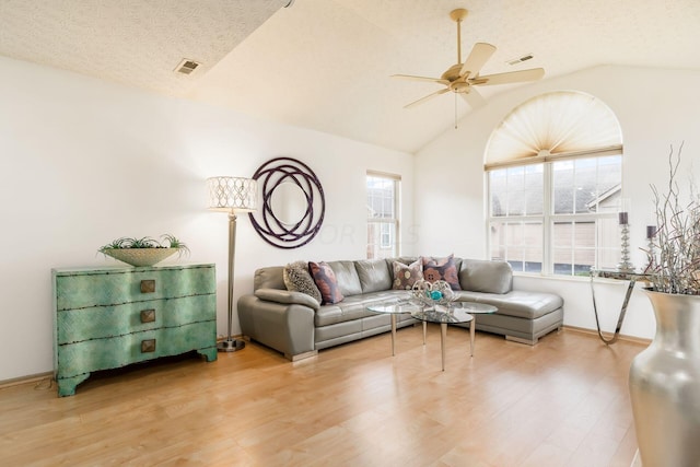 living room featuring hardwood / wood-style floors, a healthy amount of sunlight, lofted ceiling, and a textured ceiling