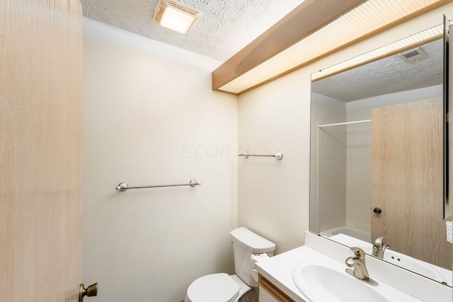 bathroom with vanity, a textured ceiling, and toilet