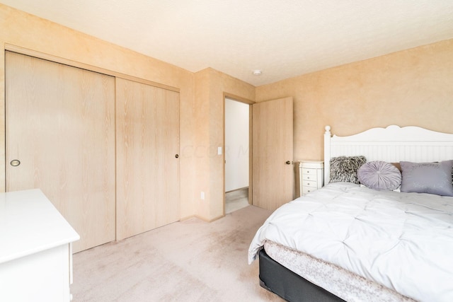 bedroom with light colored carpet and a closet